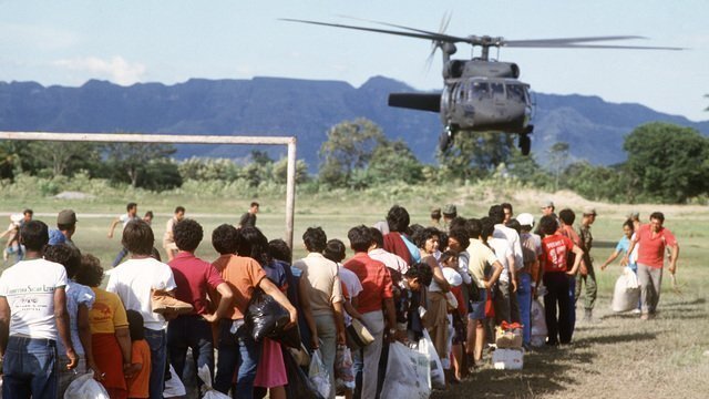 Refugees wait in line to be evacuated by a US Army UH-60A Blackhawk